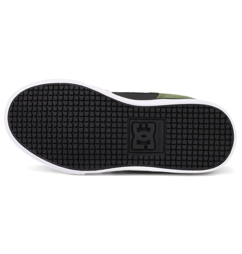 The image shows the sole of DC Shoes Kids' Pure Shoes with a textured black rubber surface and white edge. The DC Shoes logo appears in the center, highlighting this comfortable and versatile design.