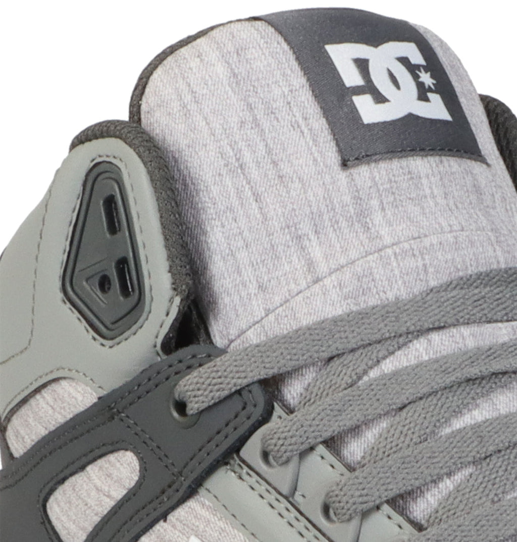 Close-up of the Men’s Pure High Shoes by DC Shoes in gray and black, highlighting the logo on the tongue, laces, eyelets, and textured fabric details—an ideal choice for those seeking comfortable footwear suitable for any occasion.