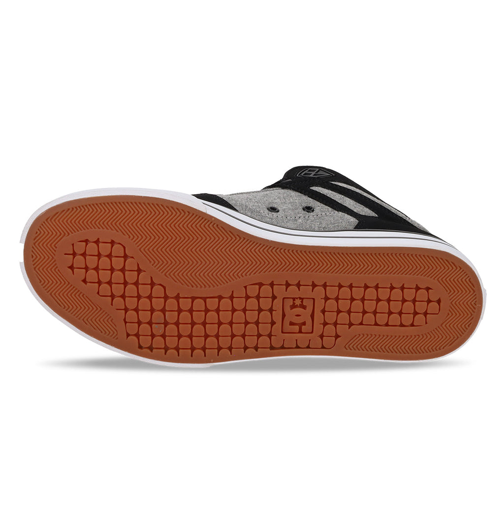 The image displays the bottom view of the DC Shoes Men’s Pure High-Top Shoes, featuring a brown rubber sole, a white midsole, and a black and gray upper. The tread showcases a distinctive square grid pattern with the DC logo at the center, highlighting both durability and comfort.