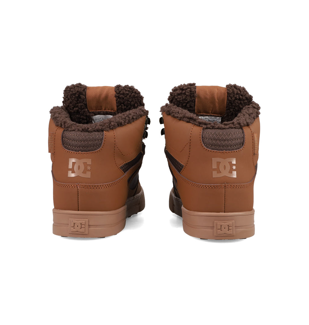 A pair of Men's Pure High Top WC Shoes by DC Shoes, featuring a brown upper, dark brown fleece lining, and vulcanized outsole, shown from the back against a white background.
