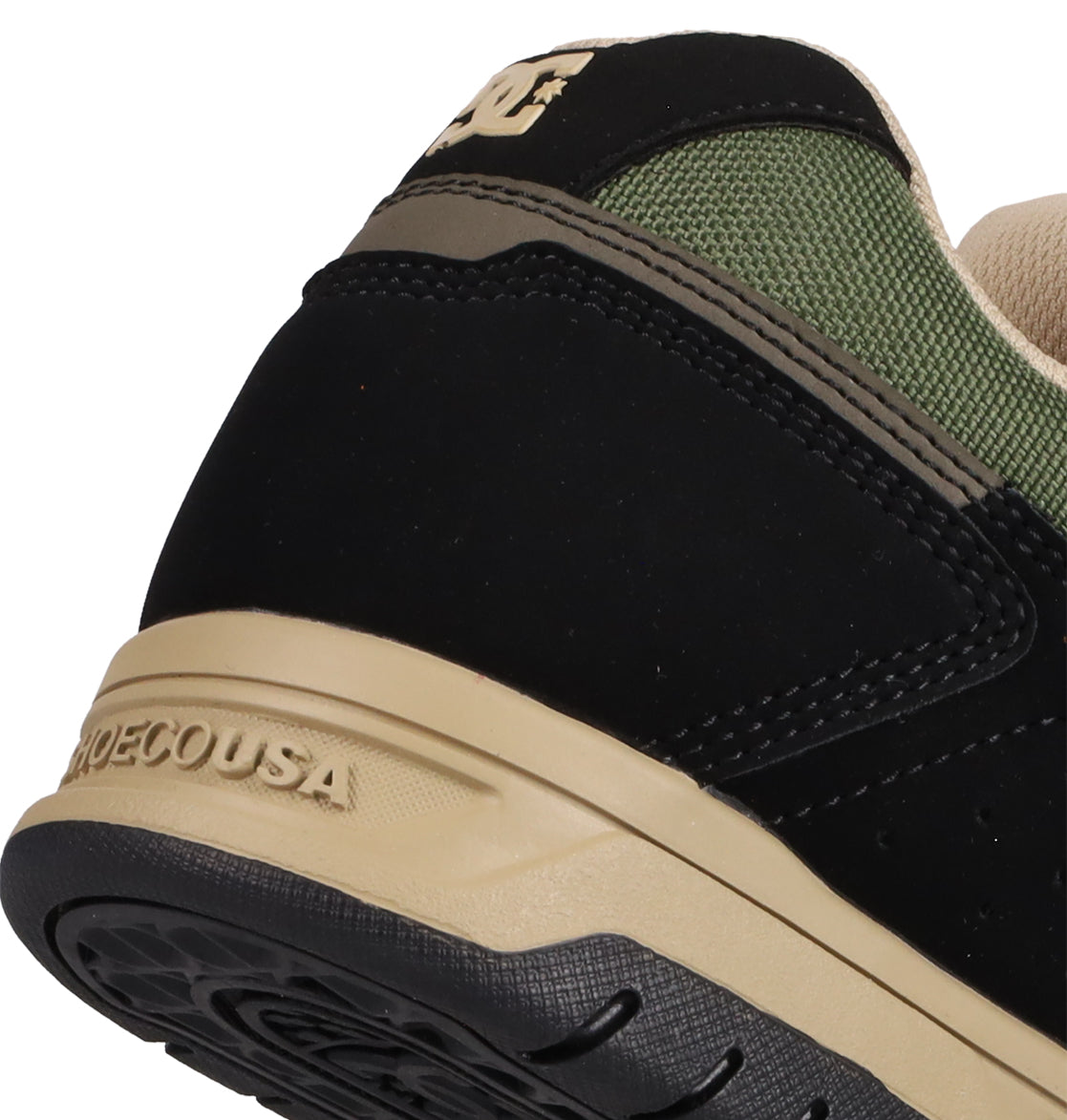 Close-up of the heel on DC Shoes Men's Stag Shoes, showcasing black, olive green, and beige colors with the DC Shoes logo on the back and SHOESUSA embossed on the durable cupsole midsole.