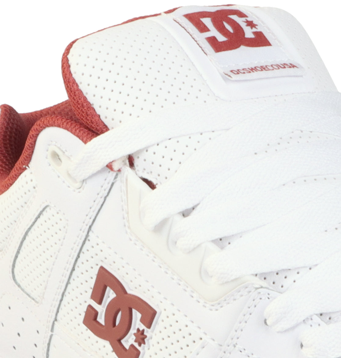 Close-up of the DC Shoes Men’s Stag Shoes in white with striking red accents, showcasing the signature DC Shoes logo in bold red on both the side and tongue. This sneaker features crisp white laces, perforated details, and an oversized puff design for enhanced style and comfort, all built on a durable cupsole to ensure long-lasting wear.