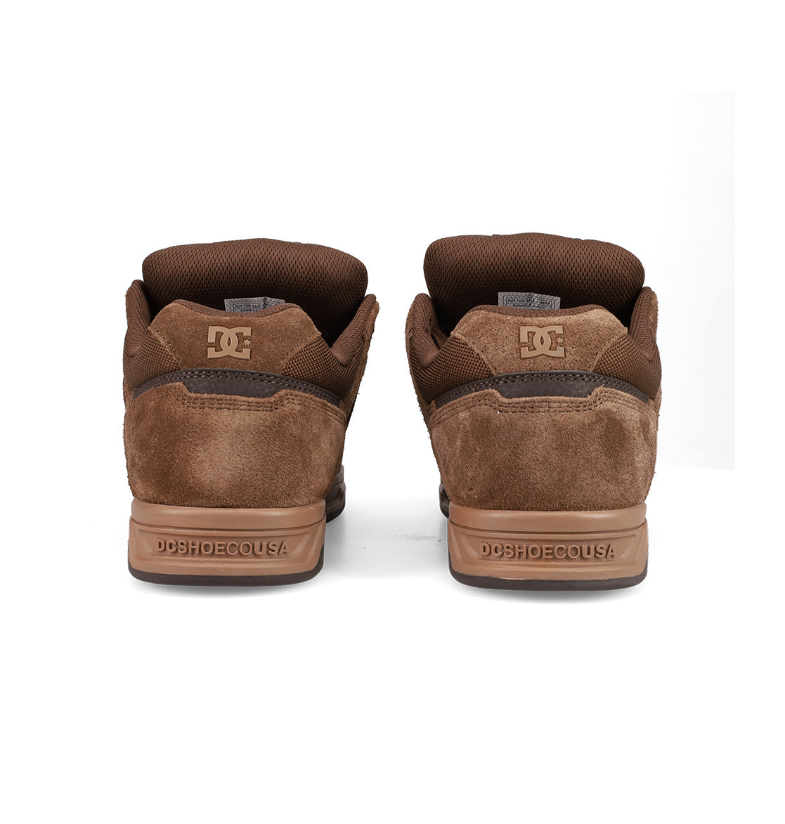 A rear view of the Men's Stag Shoes by DC Shoes, showcasing brown suede, cupsole construction, and DCSHOECOUSA embossed on the heels—a stylish nod to skate culture.