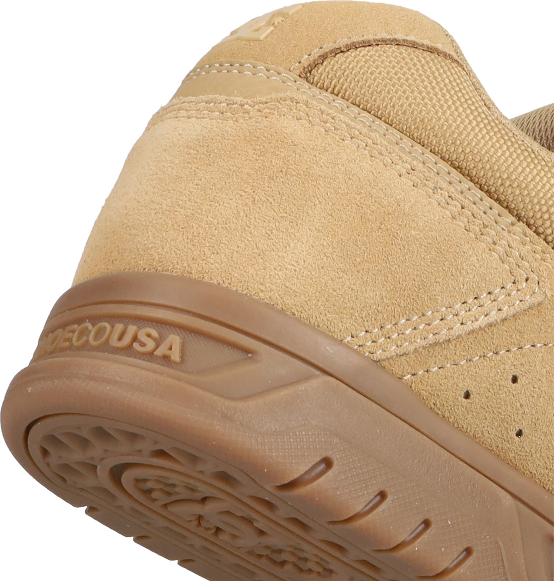 Close-up of the heel of a tan suede Men's Stag Shoe by DC Shoes, featuring a textured rubber cupsole. The DC Shoes logo is embossed on the side, showcasing stitching and material details inspired by skate culture.