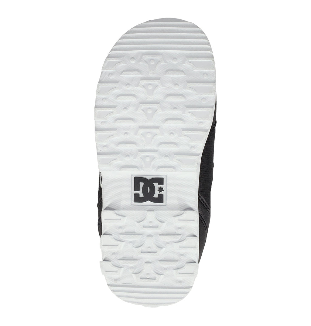 The image shows the white sole of a Kids’ Scout Snowboard Boot by DC Shoes, featuring a textured pattern and the black DC Shoes logo near the heel, designed to provide support and comfort for an active lifestyle.