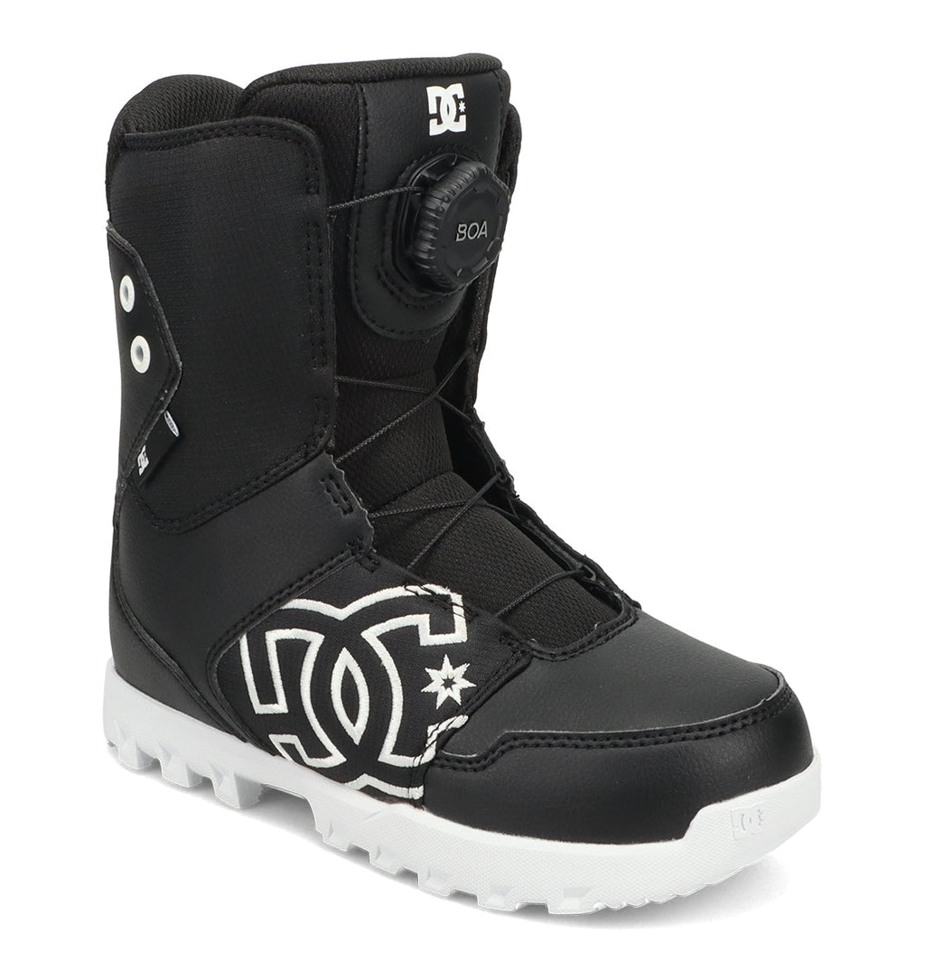 DC Shoes Kids’ Scout Snowboard Boots in black and white feature a thick sole, side logo, and a BOA dial closure system on the tongue. Specifically designed for young riders, these boots offer excellent support, comfort, and a secure fit. The boot is shown standing upright against a white background.