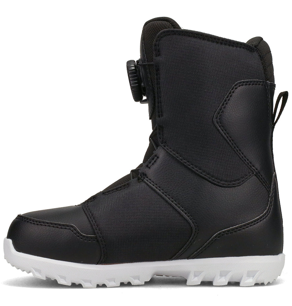 A side view of the DC Shoes Kids’ Scout Snowboard Boots in black shows a white, textured sole. These boots are equipped with a dial closure system and reinforced stitching, providing excellent support, comfort, and a secure fit—making them ideal for outdoor winter sports.