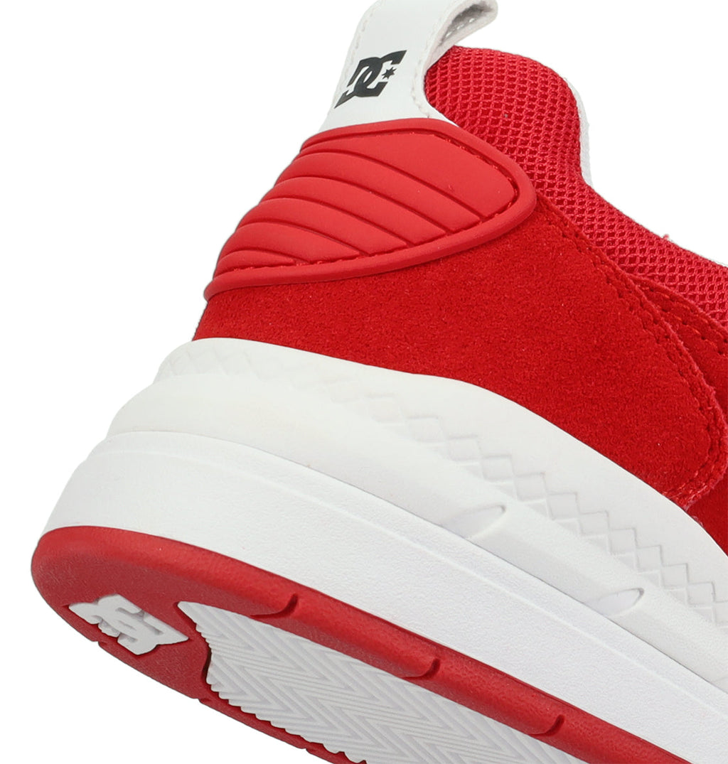 Close-up of the heel and outsole of the Men’s Ascend Skate Shoes by DC Shoes, featuring a textured rubber sole, red suede upper, mesh fabric, and a white heel tab with a black DC Shoes logo—blending classic style with modern comfort inspired by DC DNA.