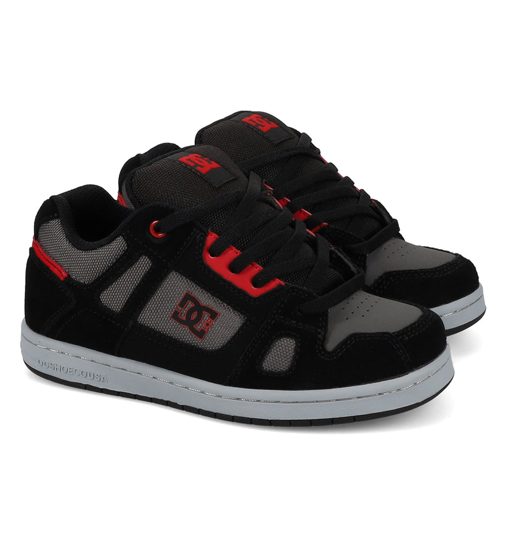 Introducing the DC Shoes Kids’ Stag Shoes—a pair of black, gray, and red skate shoes with white rubber soles, mesh panels for breathability, and bold red DC logos on the side and tongue. Designed for lightweight cushioning and impact absorption.