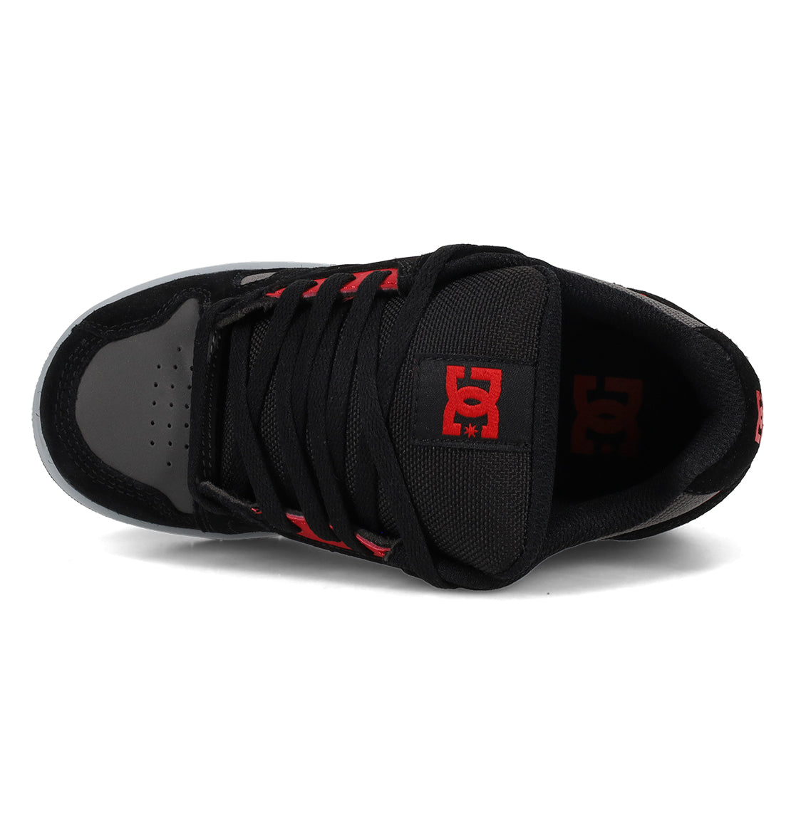 The Kids’ Stag Shoes by DC Shoes are shown from above in black and gray, featuring a red DC Shoes logo on the tongue. This sneaker includes black laces, red eyelets, and durable rubber outsoles engineered for lightweight cushioning and enhanced impact absorption.