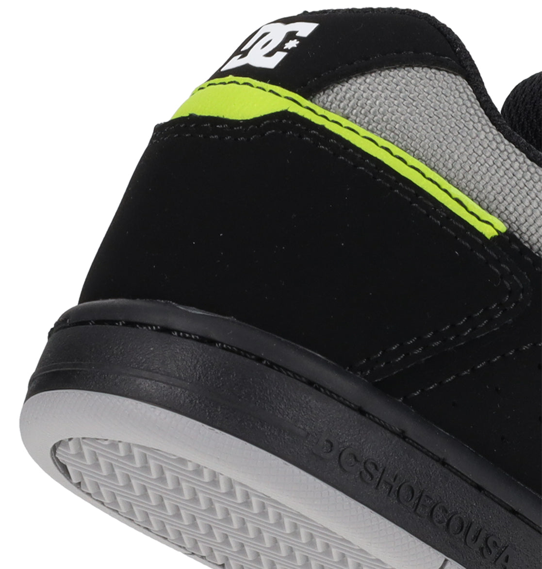 Close-up of the heel of the Kids’ Stag Shoes by DC Shoes, featuring a black and gray design with a neon yellow stripe, white DC Shoes logo on the back, and textured rubber sole—this minimal silhouette is crafted as your everyday go-to vulcanized sneaker.