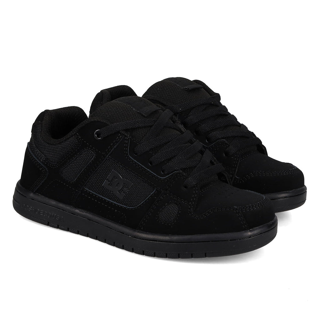 A pair of Kids’ Stag Shoes by DC Shoes in black, featuring laces, mesh panels, and textured cupsoles inspired by the brand’s iconic design, displayed side by side on a white background.
