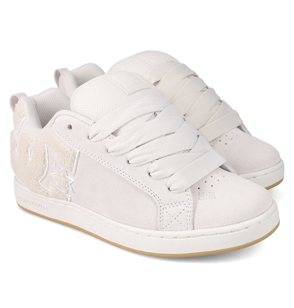 The Women's Court Graffik SD Shoes by DC Shoes feature an off-white suede upper, thick laces, textured side panels, a puffy silhouette, a light tan rubber sole, and modern stitched branding for casual style.