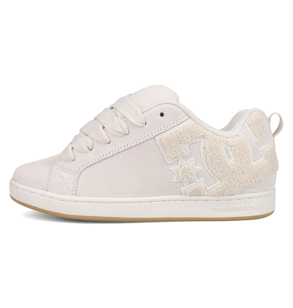 The DC Shoes Women's Court Graffik SD features a cream suede upper, thick laces, a large textured DC logo, and a light tan sole. Its puffy silhouette delivers minimalist yet stylish vibes in on-trend colorways.