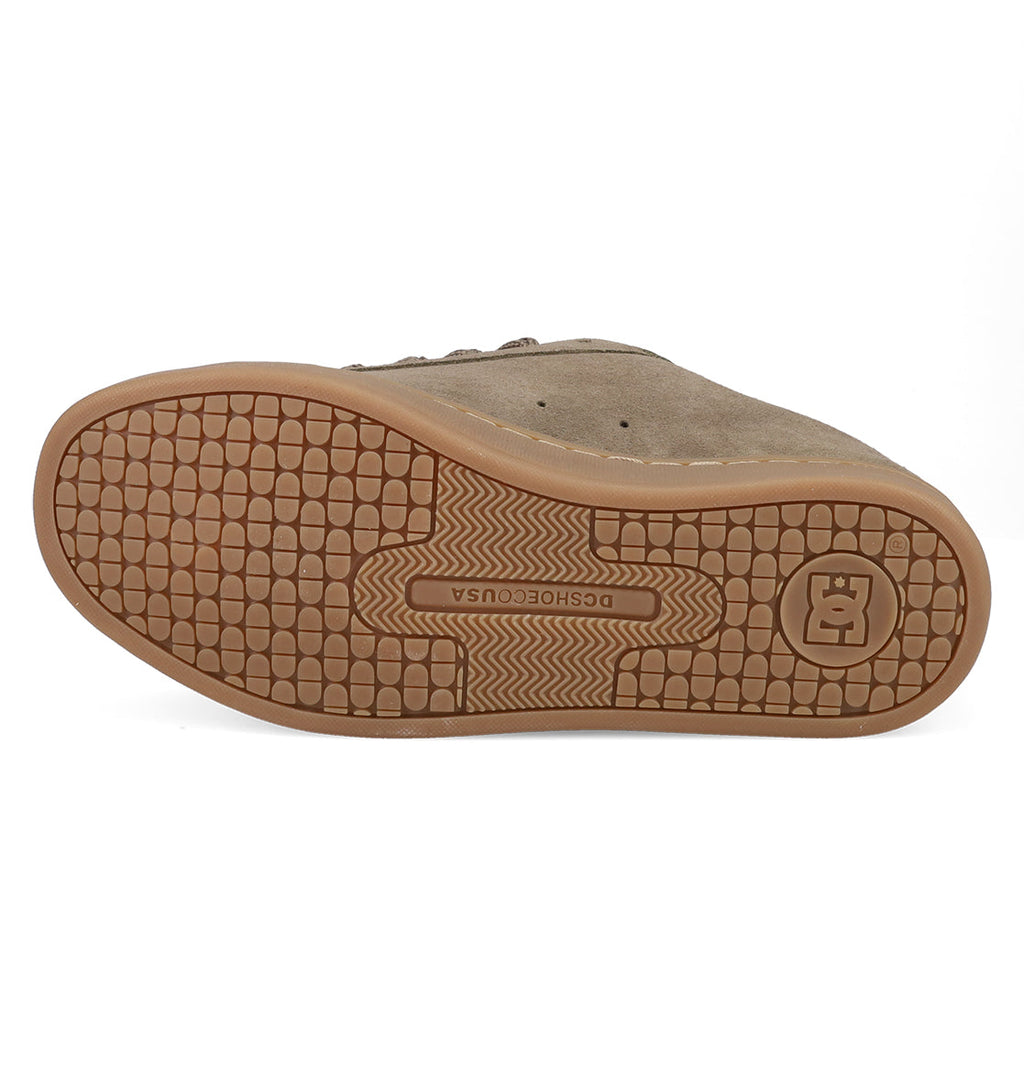The image shows the sole of a brown DC Shoes Women's Court Graffik SD Shoe, featuring a textured gridded pattern and a logo near the heel. The DC Shoes branding at the center complements its puffy silhouette for a trendy look.
