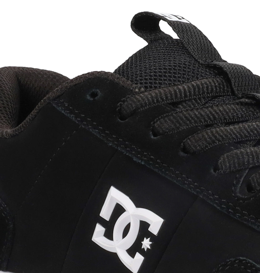 Close-up of the Men’s Astrix Shoes by DC Shoes—a black skate shoe with black laces and a mesh tongue, featuring a white DC logo on the side. Perfect for street skateboarding and designed to provide excellent board control.