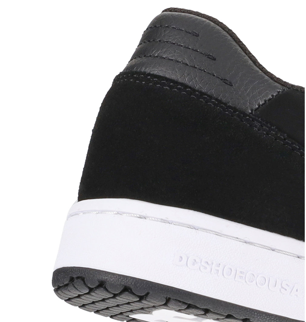 Close-up of the heel of the Men’s Astrix Shoe by DC Shoes in black and white, showcasing visible stitching details, a textured black heel collar, and “DCSHOECOUSA” embossed on the white rubber midsole—engineered for superior board control during street skateboarding.