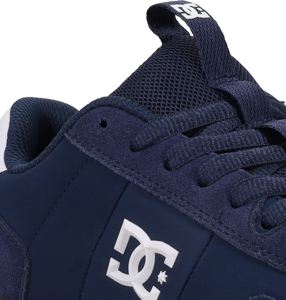 Close-up of the DC Shoes Men’s Astrix in navy blue, highlighting the laces, tongue, and bold white DC Shoes logo on the side—ideal for enhanced board control during street skateboarding.