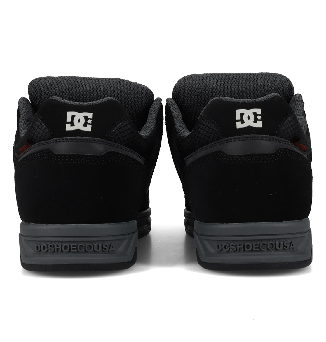 Back view of a pair of Men’s Stag Winterized Shoes by DC Shoes in black, showcasing gray soles with the iconic DC logo on the heel and “DCSHOECOUSA” text along the midsole. Crafted with lightweight cushioning to deliver enhanced comfort during every session.