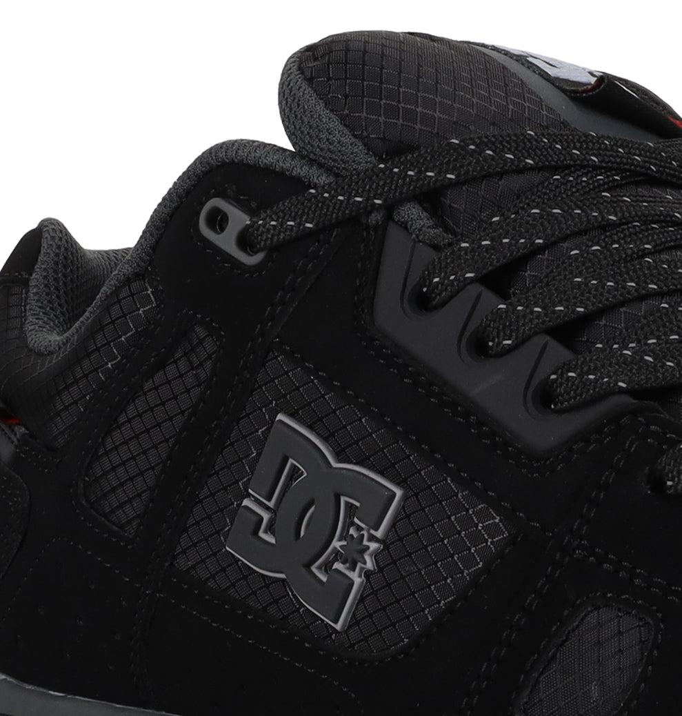Close-up of the DC Shoes Men’s Stag Winterized Shoe in black and gray, showcasing its textured leather surface with the DC Shoes logo on the side and black laces threaded through multiple eyelets. Designed for comfort, this sneaker delivers lightweight cushioning and enhanced impact absorption for all-day wear.