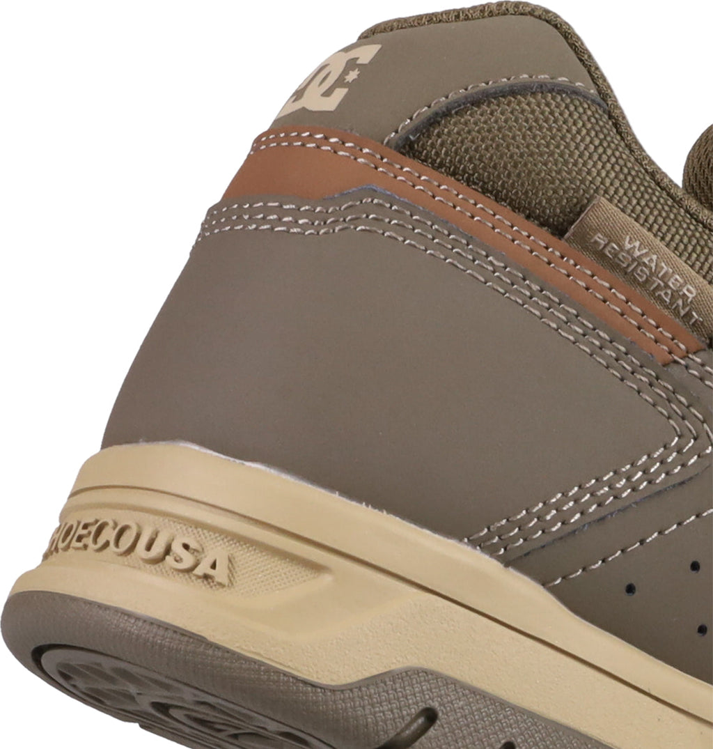 Close-up of the heel on Men's Stag Shoes by DC Shoes in brown and tan, featuring the “DC” logo, “WATER RESISTANT” text, textured stitching, and a sturdy cupsole inspired by skate culture.