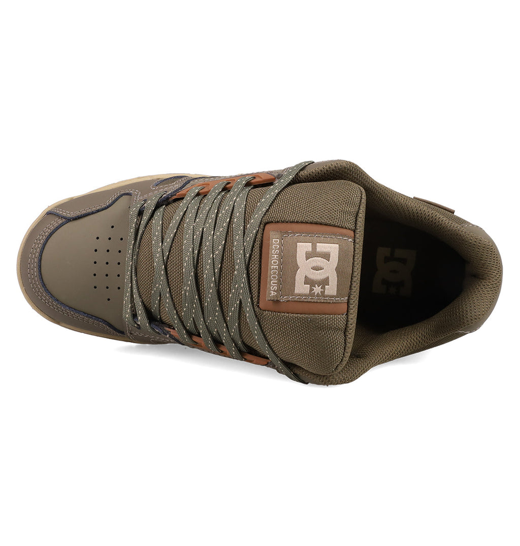 Top view of DC Shoes Men's Stag Shoes in brown and olive green, featuring laces, perforated toe box, cupsole construction, and a tongue logo patch for classic skate style.