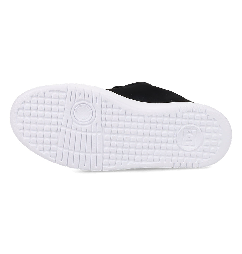 The image displays the bottom view of a black DC Shoes Women’s Court Graffik Platform Shoe, highlighting its white rubber sole with a circular pattern and textured grid design for enhanced traction. This popular women’s style is known for its bold appearance and reliable grip.
