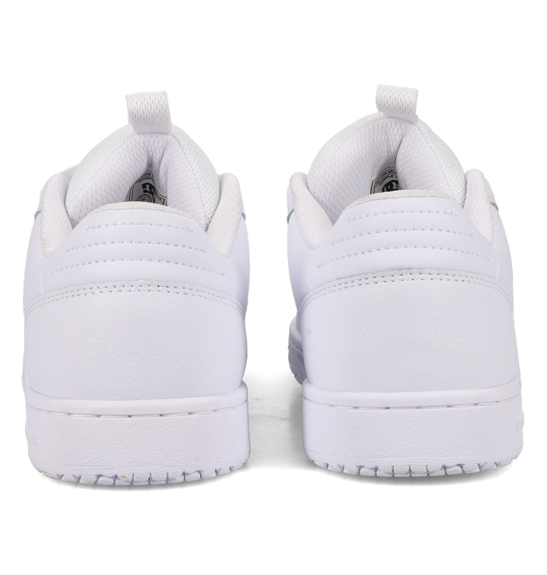 A pair of Women’s Astrix Shoes by DC Shoes in white, viewed from the back to highlight the heels, textured soles engineered for board control, and padded collars—all set against a plain white background.