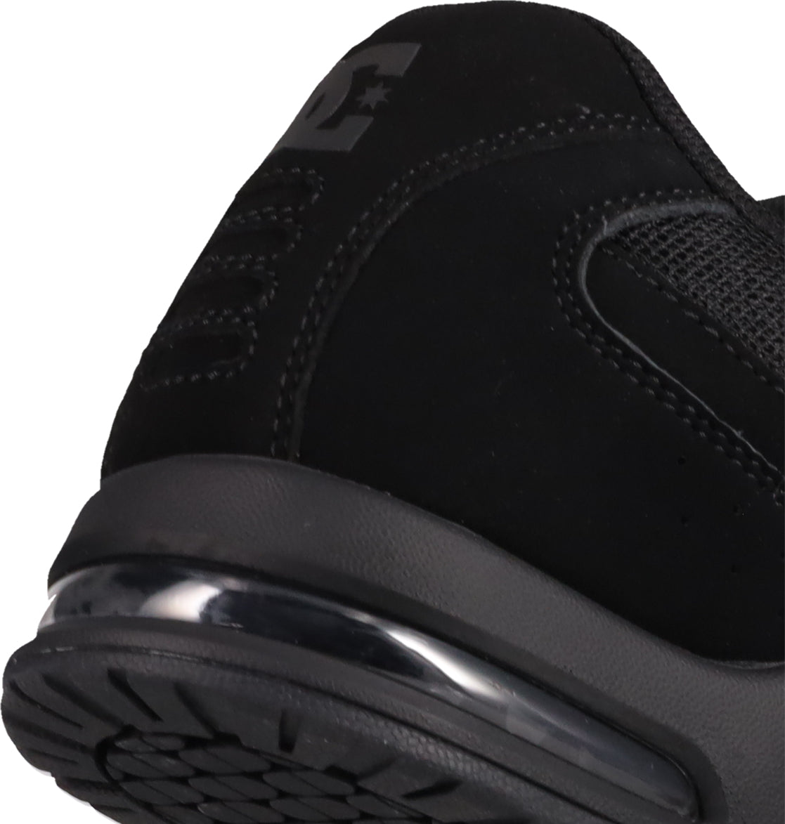 Close-up of the heel and sole of the black Men's AT-2 Shoes by DC Shoes, highlighting the textured airband outsole tread, visible air cushion in the sole, detailed stitching, and part of the logo on the upper.
