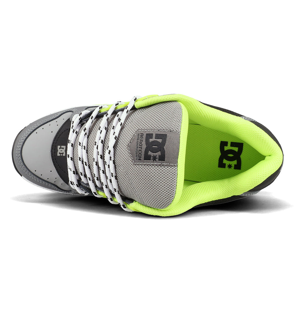 A top view of the Men’s AT-2 Shoes by DC Shoes in grey, showcasing white laces with black dots, a mesh tongue, and a neon green inner lining. The DC Shoes logo appears on both the insole and tongue, while the AEROTECH ventilation system provides breathability and superior cushioning for all-day comfort.