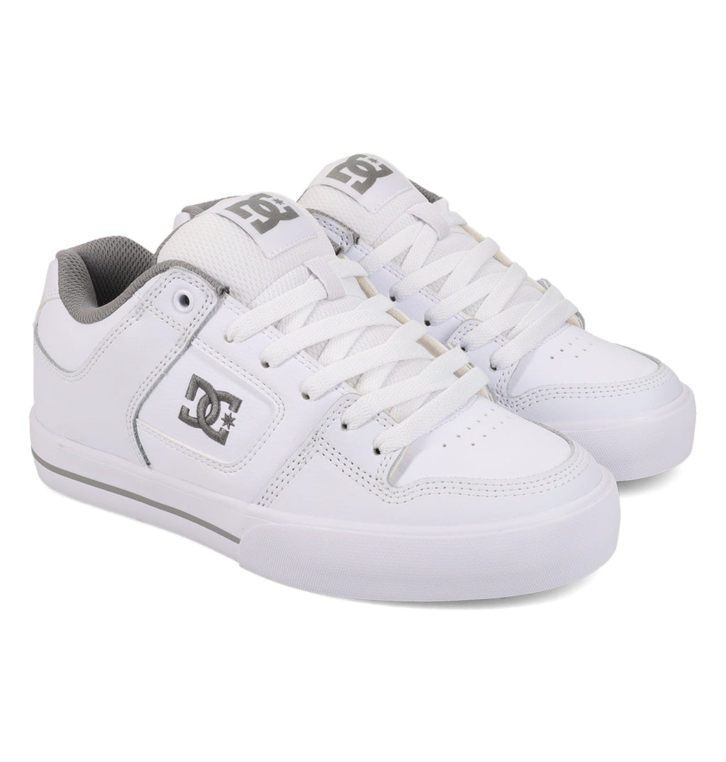 A pair of Women’s Pure Shoes by DC Shoes, featuring a white design with gray accents, white laces, and a gray DC logo on the side. These skate shoes offer lightweight cushioning for enhanced impact absorption and are displayed against a white background.