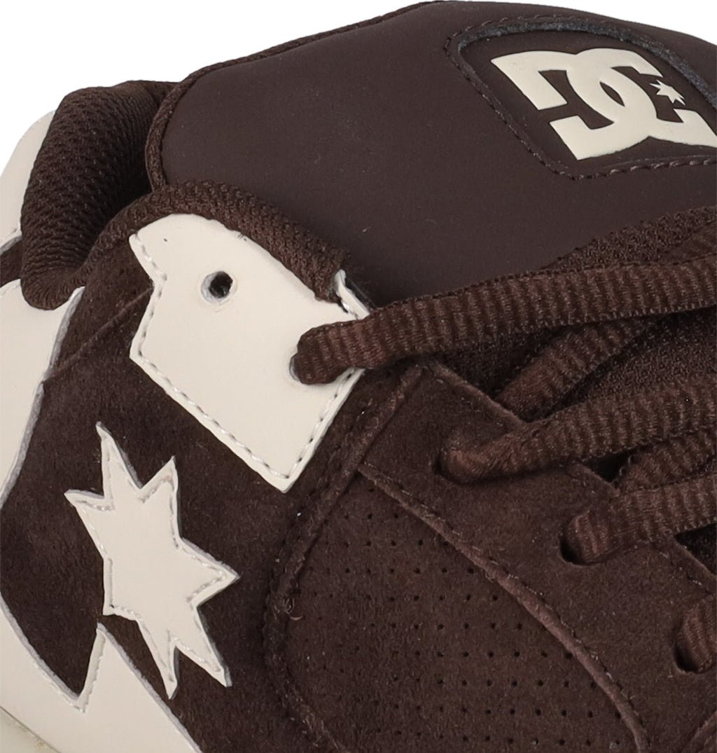 Close-up of a brown and white Men's DC Command SE Shoe by DC Shoes, showing laces, partial logo on the tongue, star detail on the side, and featuring suede and leather materials with signature cushioning for modern comfort.