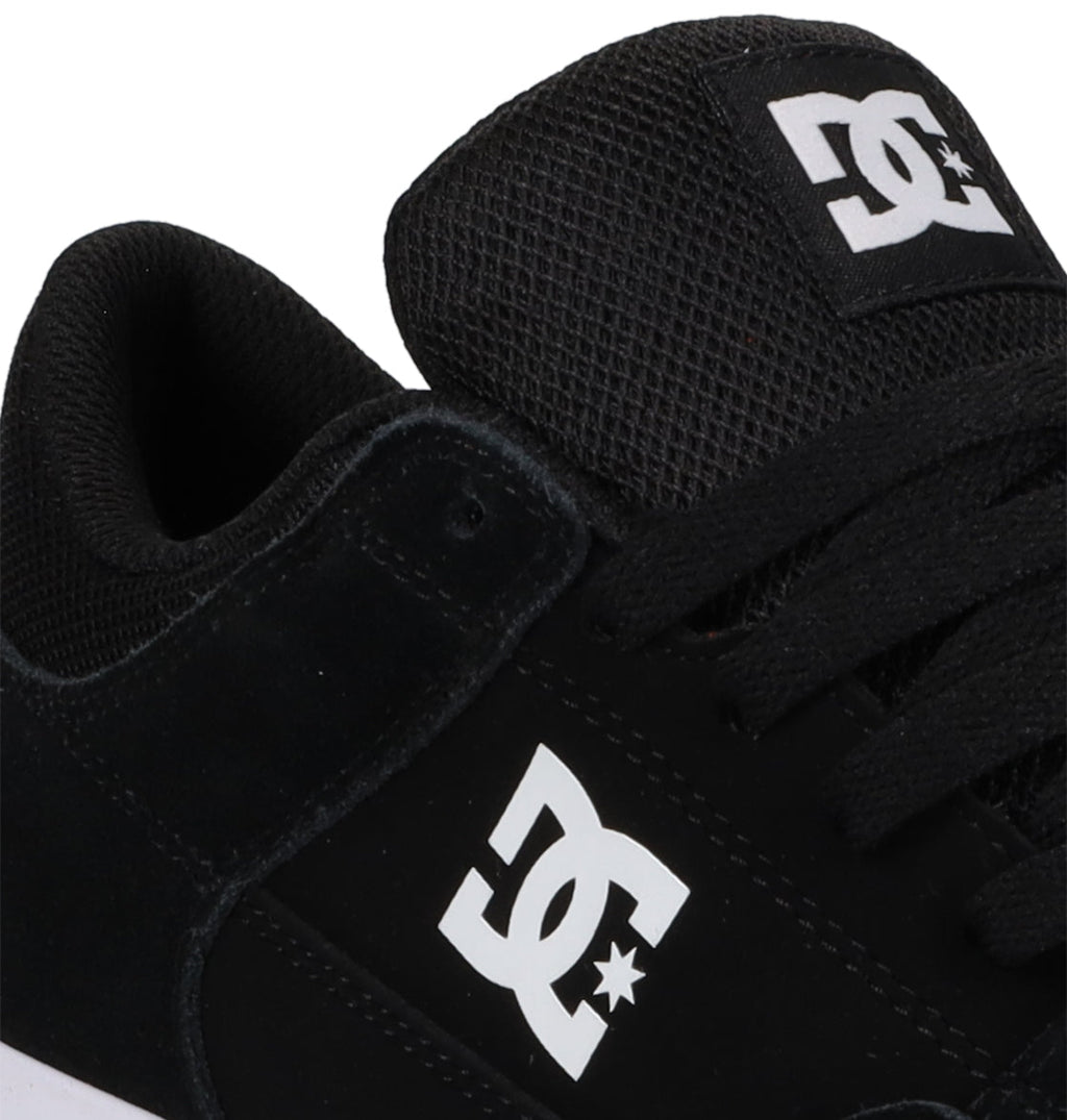 Close-up of the Men’s Onyx Shoes by DC Shoes in black, showcasing a white DC logo on the side and tongue, black laces, and mesh detailing on the tongue. The minimal silhouette makes these skate shoes an everyday go-to for both style and comfort.