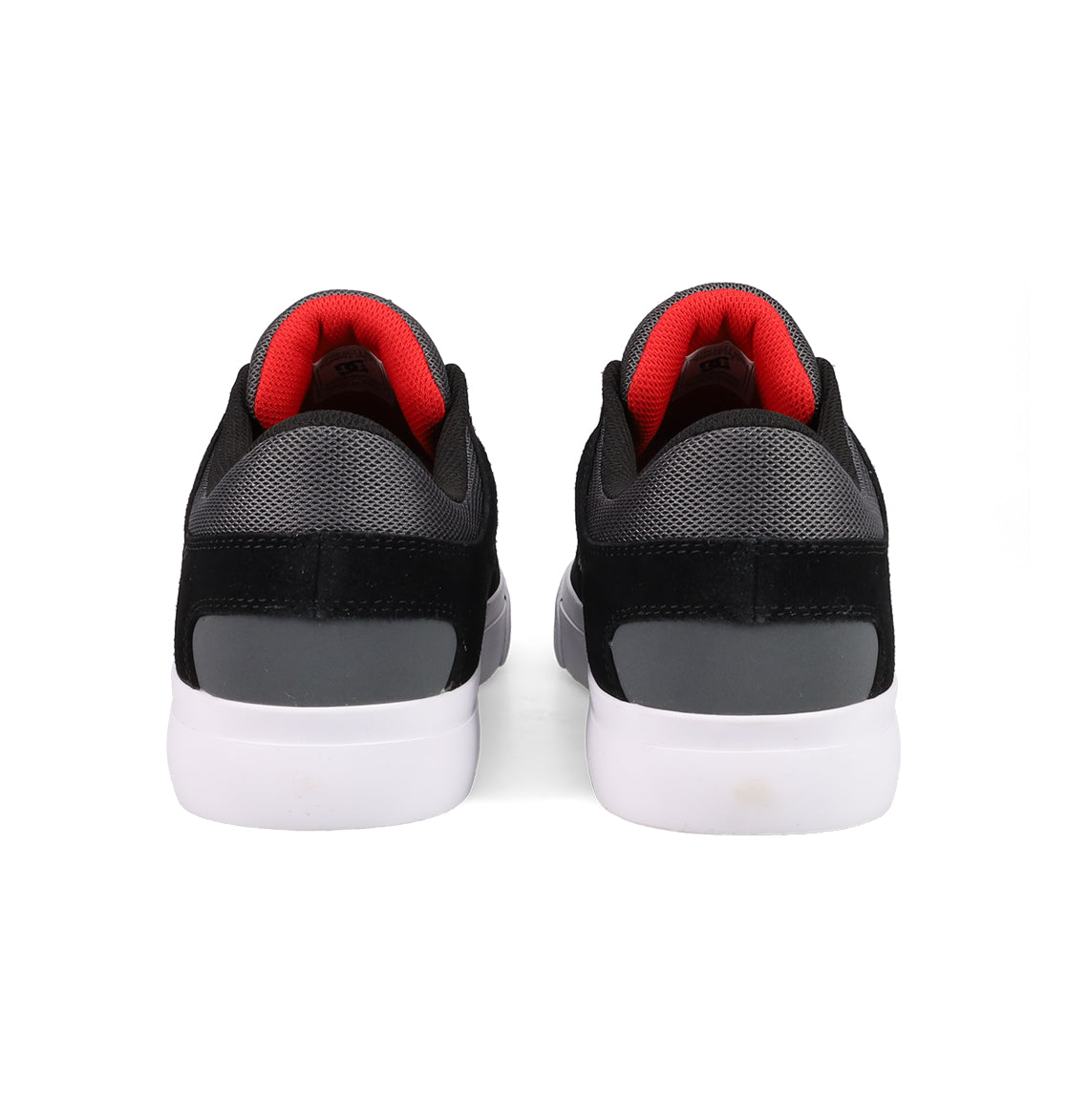 DC Shoes Men's Onyx Shoes in black and gray with white soles and red inner lining are displayed from the back, highlighting their minimal silhouette, against a plain white background.