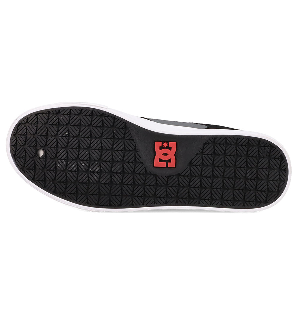 The image displays the black rubber sole of the Men's Onyx Shoes by DC Shoes, featuring a minimal silhouette with a white outer edge, a red and white DC Shoes logo by the heel, and a repeating diamond tread pattern.