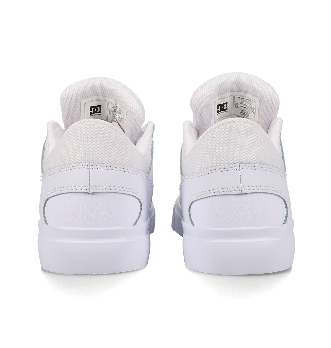 Back view of a pair of Men’s Onyx Shoes by DC Shoes in white, featuring mesh detailing around the ankle, visible DC branding on the tongue tags, and clean, flat soles—an everyday vulcanized shoe crafted for both comfort and style.
