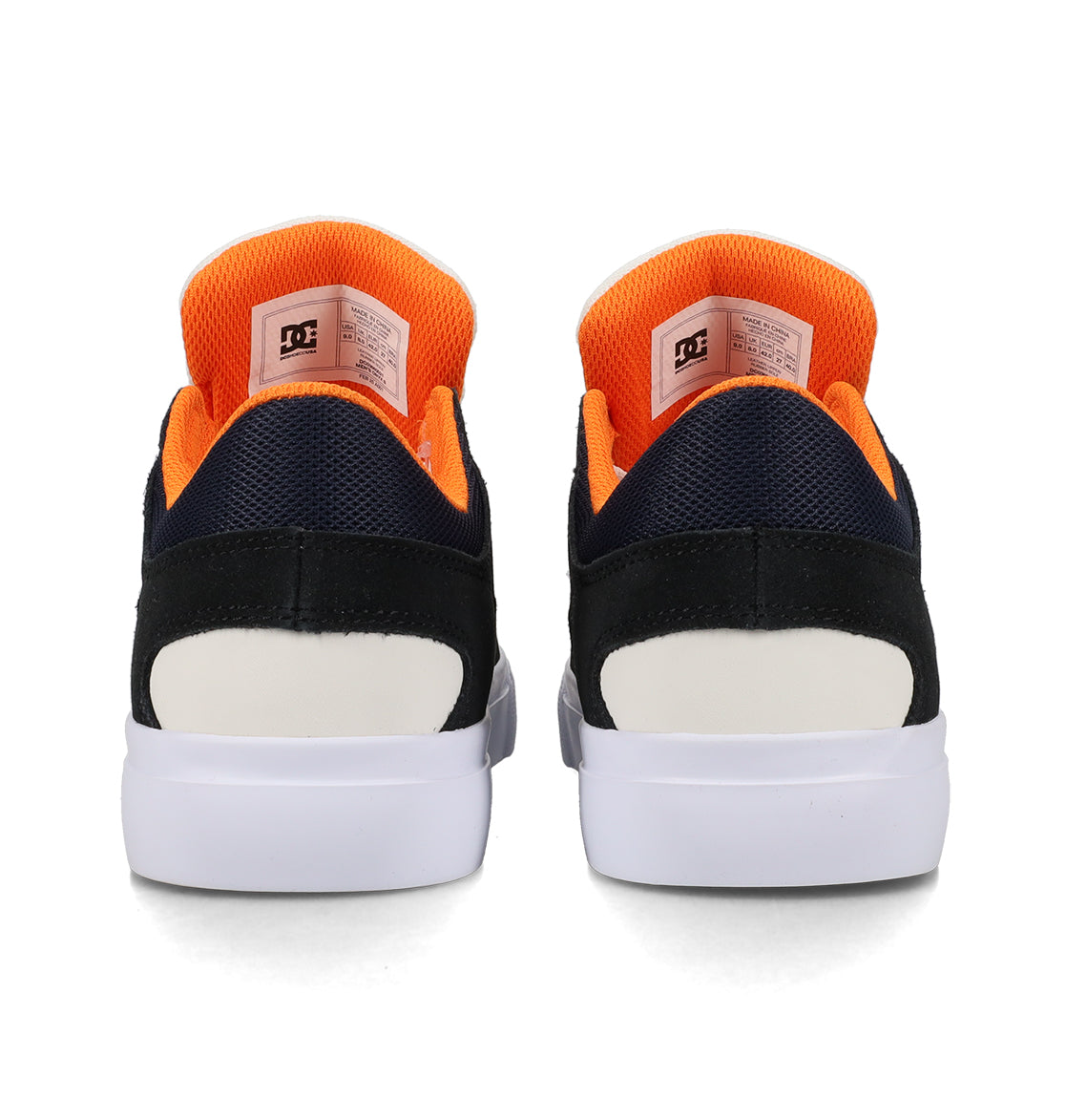 Back view of a pair of DC Shoes Men’s Onyx Skate Shoes featuring a minimal silhouette in black with white and orange accents, showcasing the DC logo on the orange inner lining and white soles—a versatile vulc shoe for everyday wear.