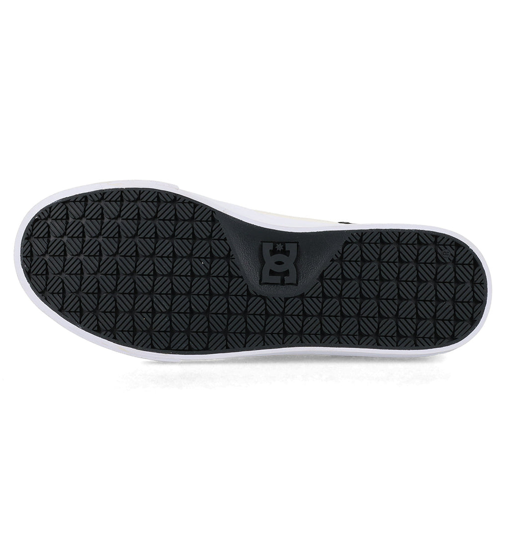 Black rubber sole of the Men’s Onyx Skate Shoes by DC Shoes, featuring a geometric tread pattern and the DC Shoes logo in the center, bordered by a white edge. Photographed against a plain white background, this sole is crafted for the minimalist silhouette of an everyday go-to vulc shoe.