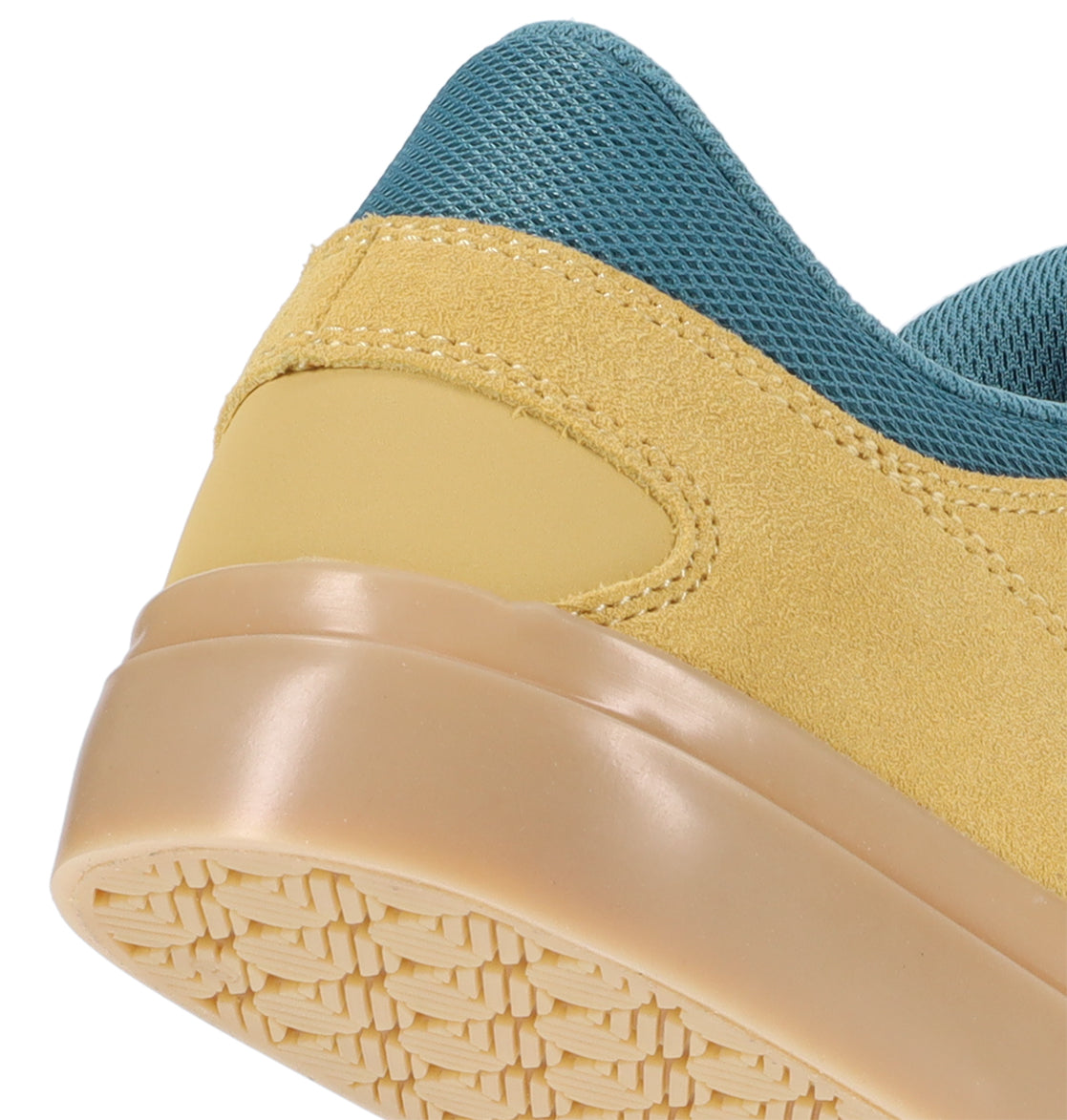Close-up of the heel and sole of the DC Shoes Men’s Onyx Skate Shoes, featuring a yellow suede upper, tan rubber midsole, and teal mesh collar that highlight its minimal silhouette.
