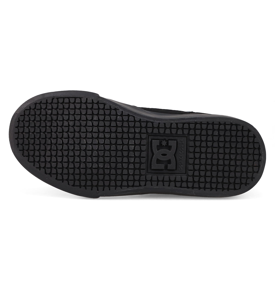 The image displays the black rubber sole of the Kids' Onyx Shoes by DC Shoes, featuring a hexagonal tread pattern and an embossed DC logo at the center, emphasizing its streamlined silhouette.