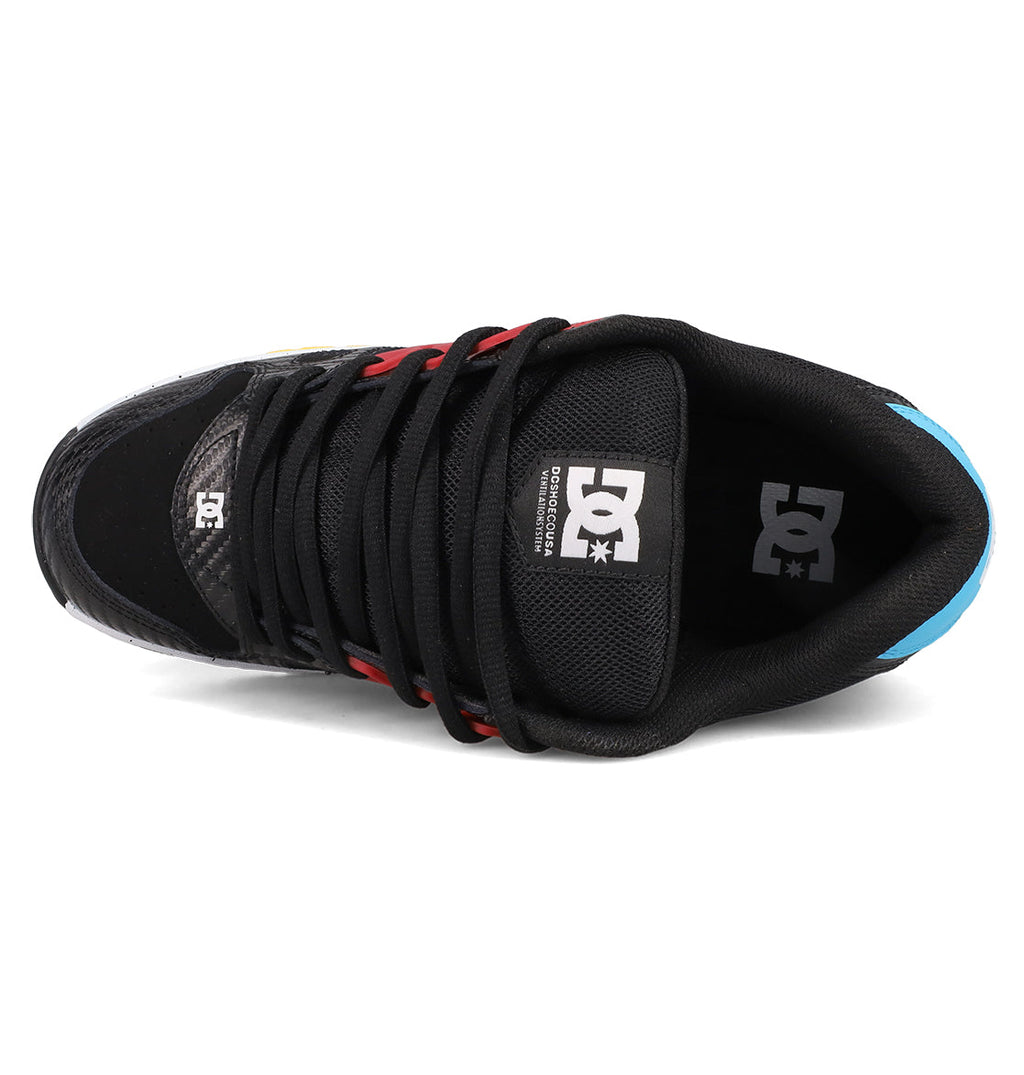 Top view of DC Shoes Men's AT-2: a black skate shoe with black laces, red and yellow accents, blue heel, and DC logo on tongue and insole. AEROTECH ventilation delivers breathable comfort for every ride.