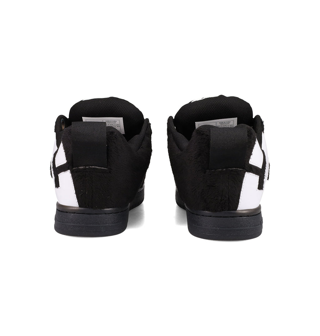 The Men's Court Graffik Puff Shoes by DC Shoes feature a furry black and white upper, exaggerated design, black soles, and heel tabs. Shown from the back on a white background.