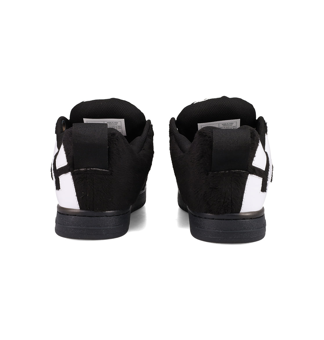 The Men's Court Graffik Puff Shoes by DC Shoes feature a furry black and white upper, exaggerated design, black soles, and heel tabs. Shown from the back on a white background.