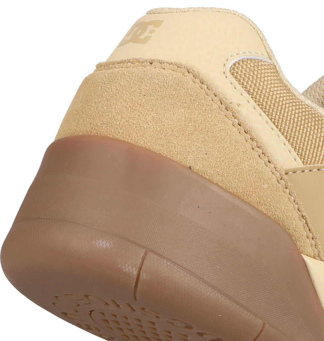 Close-up of the heel of DC Shoes Men's Fractal S, featuring beige and tan suede, textured panels, a brown rubber sole, street-ready style, and a partial DC logo on the back.