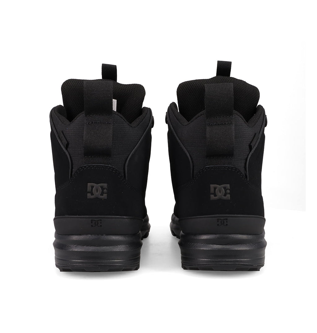 A pair of Men's DC Tarmont Shoes by DC Shoes in black, viewed from the back with visible DC logos and heel pull tabs, styled for streetwear and displayed on a plain white background.