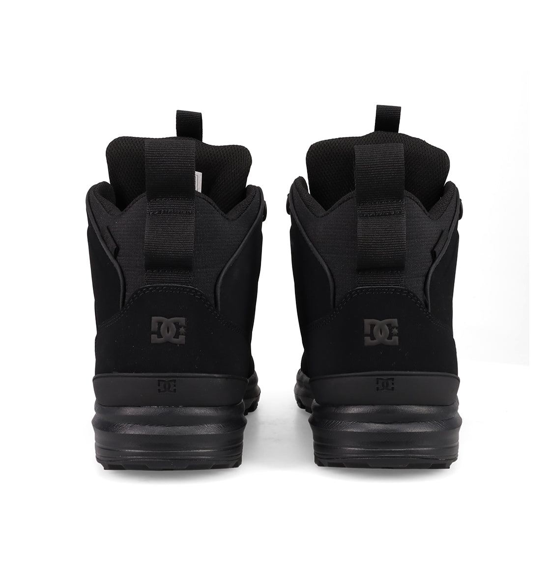A pair of Men's DC Tarmont Shoes by DC Shoes in black, viewed from the back with visible DC logos and heel pull tabs, styled for streetwear and displayed on a plain white background.