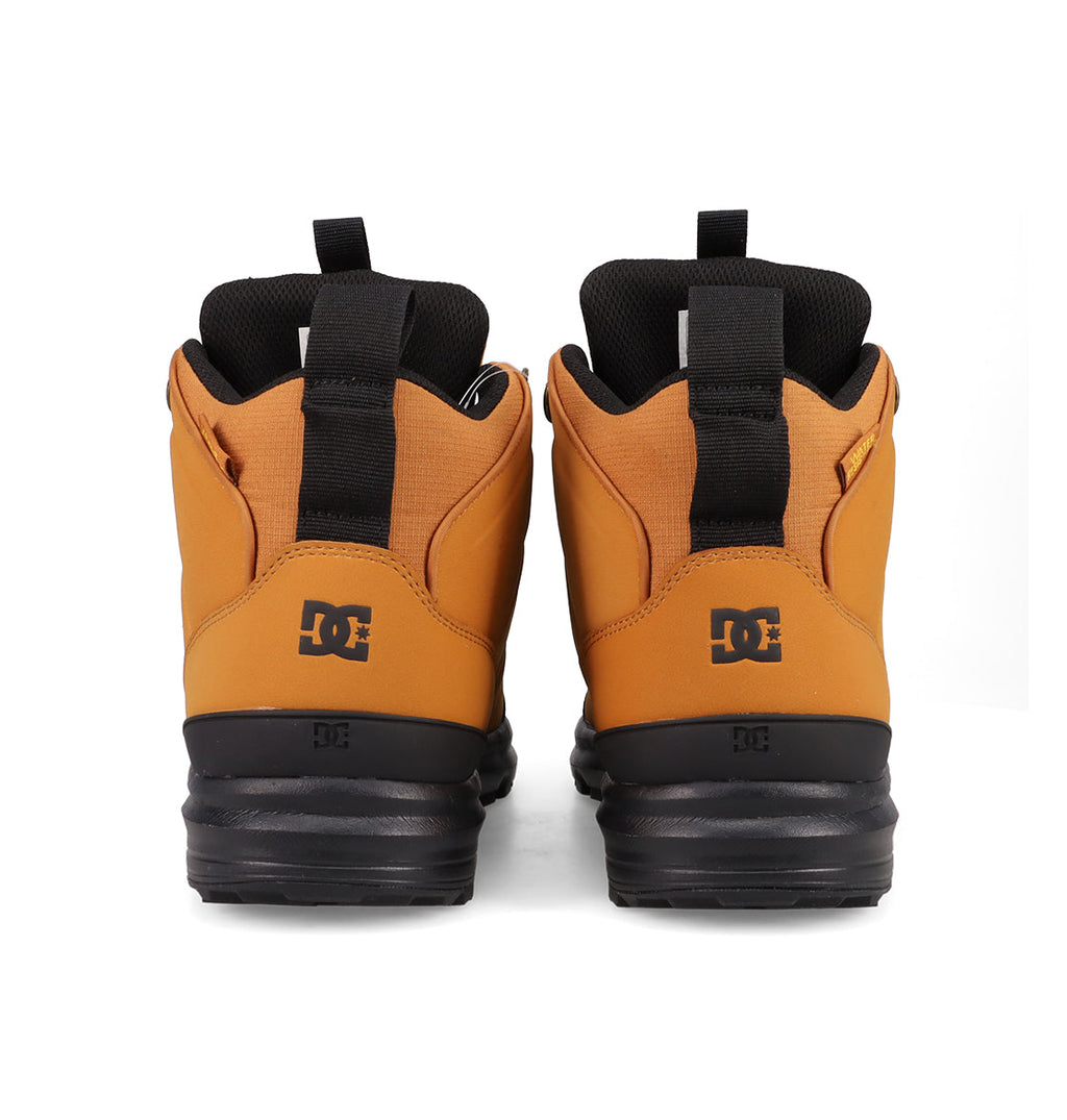 A pair of tan and black Men's DC Tarmont Shoes by DC Shoes, shown from the back with black pull tabs and visible DC logo on each heel—ideal for street style and all-weather wear.