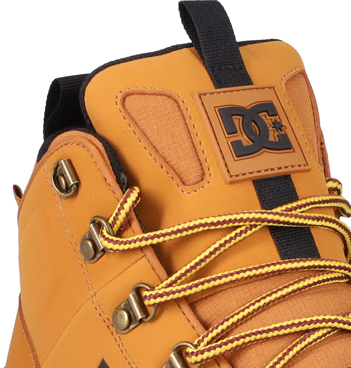 Close-up of the Men's DC Tarmont Shoes by DC Shoes, featuring tan outdoor styling, yellow and red striped laces, metal eyelets, and a black DC logo on the tongue. These boots blend rugged, all-weather performance with street-inspired design.