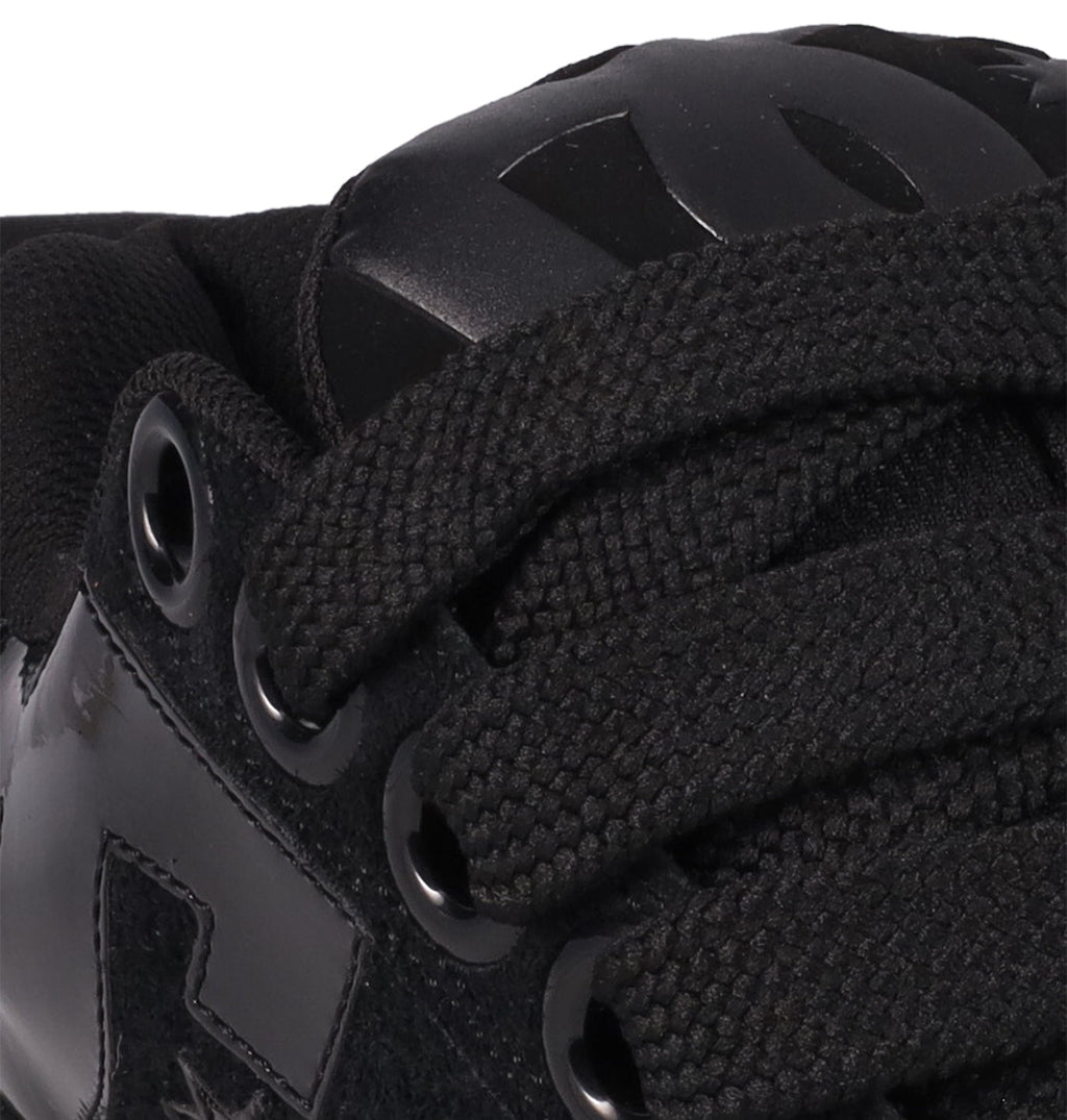 Close-up of DC Shoes Women's Court Graffik Puff Shoes in black, featuring thick laces, eyelets, and a shiny side logo. The puffy silhouette and textured details make these sneakers stand out as statement footwear.
