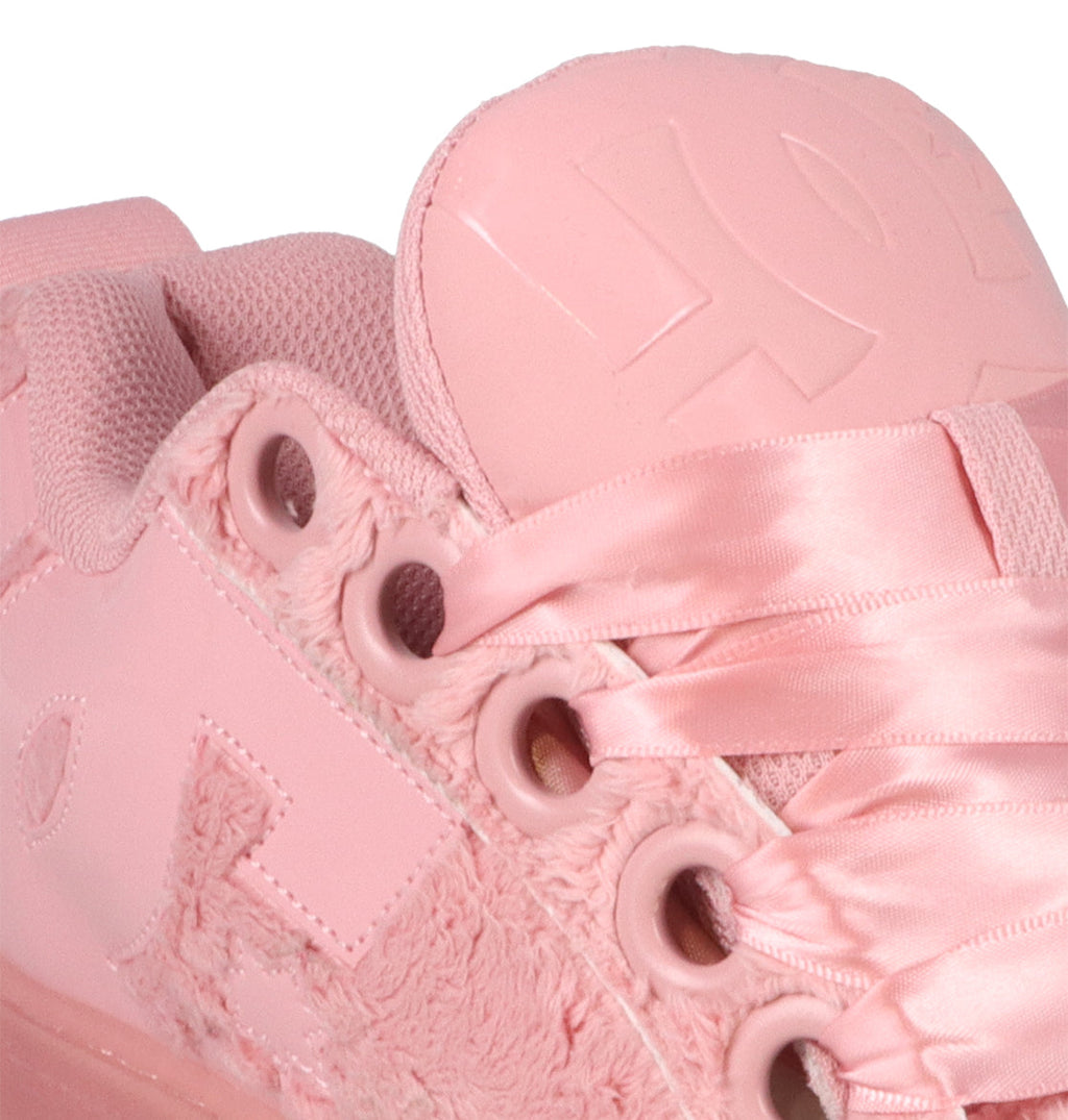 Close-up of the DC Shoes Women’s Court Graffik Puff sneaker in pink, featuring satin laces, embroidered and textured accents, and breathable mesh fabric near the ankle. The puffy tongue displays embossed lettering, showcasing a silhouette inspired by classic Court Graffik Puff fashion sneakers.
